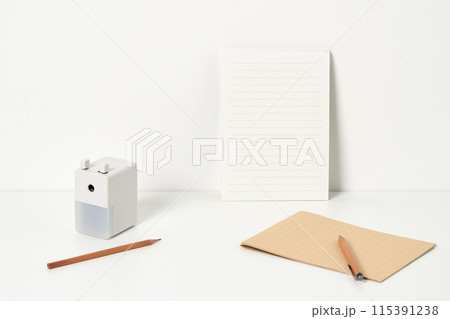 a pencil sharpener and pencil in front of a letter paper 115391238