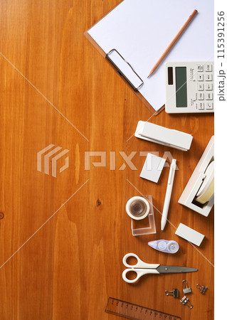 unorganized office supplies on wooden desks unorganized office supplies on wooden desks 115391256
