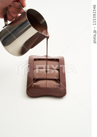 melted chocolate poured into a chocolate mold melted chocolate poured into a chocolate mold 115391546
