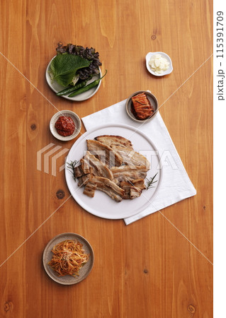 a table set of pork belly dishes with vegetables 115391709