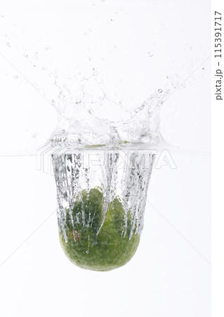 fresh lime falling into the water 115391717