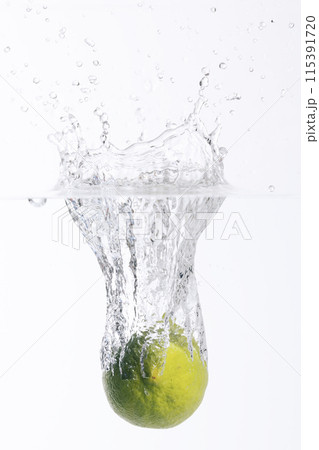 fresh lime falling into the water fresh lime falling into the water 115391720