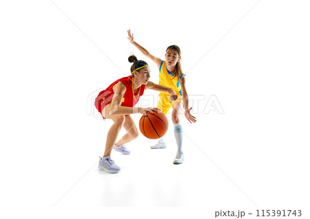 Strategic moment in basketball game between two female players, young women in red and yellow sportswear training isolated on white studio background 115391743