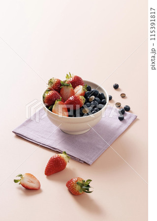 a bowl of cherries and blueberries 115391817