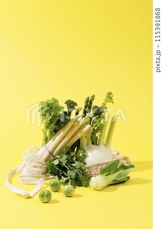 a pile of green and white vegetables against a yellow background 115391868