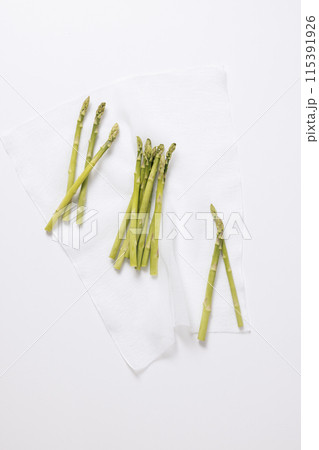 a pile of asparagus arranged on a white cloth a pile of asparagus arranged on a white cloth 115391926