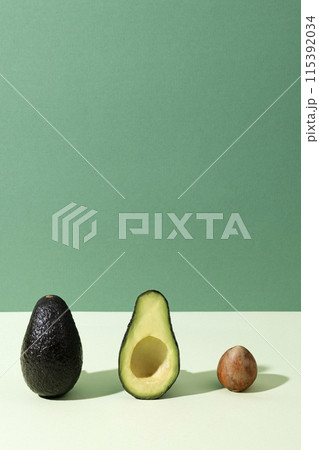 the arrangement of avocados and seeds on a green background the arrangement of avocados and seeds on a green background 115392034