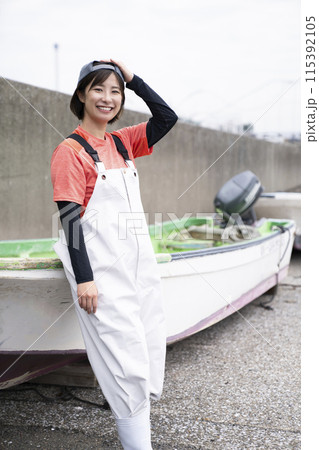 漁港で働く若い女性 漁港で働く若い女性 115392105
