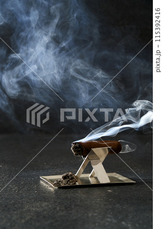 a smoking cigar and pedestal a smoking cigar and pedestal 115392416