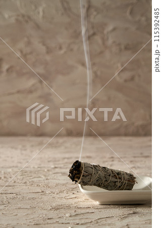 Smouldering stick with smoke 115392485