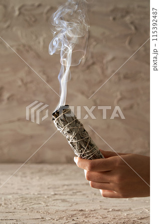 a smoky smoky hand holding a smoky stick 115392487