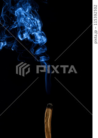 Smudge stick with smoke against a dark background 115392502