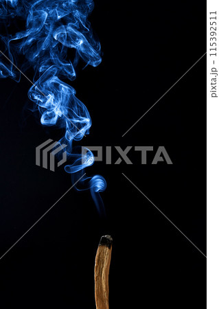 Smudge stick with smoke against a dark background Smudge stick with smoke against a dark background 115392511