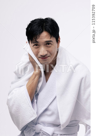 a middle aged man who wipes his face with a white towel 115392709