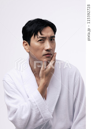 a middle aged man who touches his face with his hands a middle aged man who touches his face with his hands 115392728
