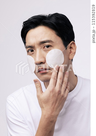 a middle aged man with a circular cotton pad 115392819