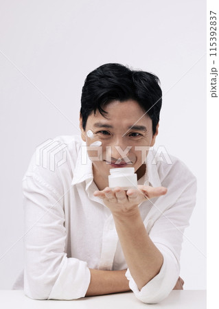 a middle aged man staring at a cream barrel in his palm with a smile on his face a middle aged man staring at a cream barrel in his palm with a smile on his face 115392837