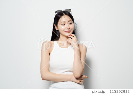 an Asian woman staring sideways with her hands on her chin an Asian woman staring sideways with her hands on her chin 115392932