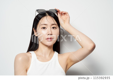 an Asian woman staring straight ahead without her sunglasses an Asian woman staring straight ahead without her sunglasses 115392935