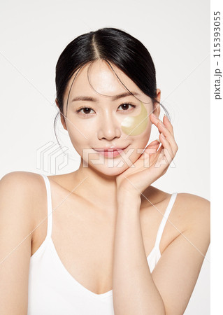 Asian woman staring straight ahead with eye patches on her face 115393055