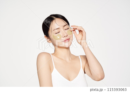 Asian woman posing with eye patches on both cheeks Asian woman posing with eye patches on both cheeks 115393063
