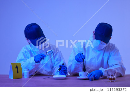 CSI Scientific Investigation Unit male and female researchers collecting fingerprints from crime and incident sites with blue lights and checking evidence with magnifying glass 115393272