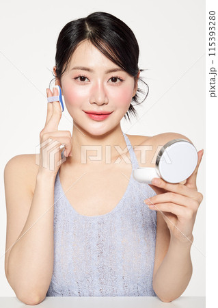 Asian Woman Putting Cushion Facts on Her Face 115393280