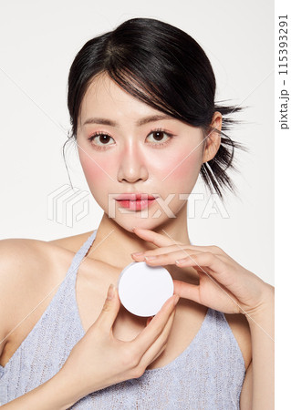 Asian woman wearing makeup and holding cushion compacts Asian woman wearing makeup and holding cushion compacts 115393291