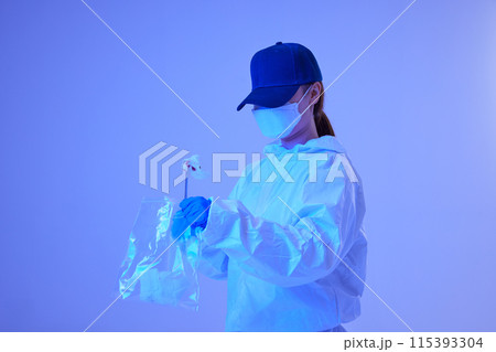 CSI female researcher collecting evidence in envelopes at crime and incident sites with blue lights 115393304