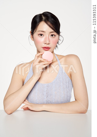 A Beautiful Asian Woman Holding a Pink Cushion Fact 115393311