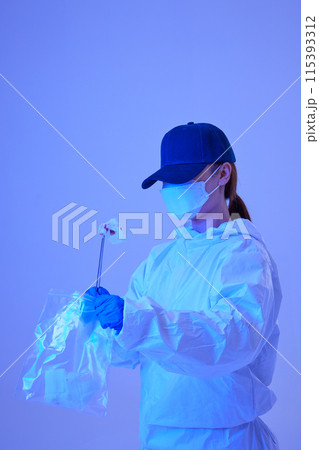 CSI female researcher collecting evidence in envelopes at crime and incident sites with blue lights 115393312