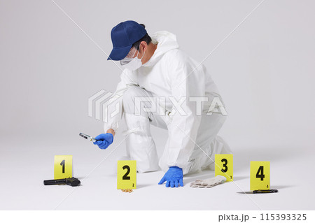 Evidence Marker A male researcher who checks evidence with a magnifying glass at the crime scene and at the incident site Evidence Marker A male researcher who checks evidence with a magnifying glass at the crime scene and at the incident site 115393325