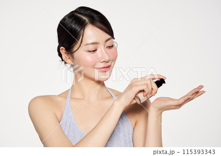 an Asian woman who applies foundation to her palms an Asian woman who applies foundation to her palms 115393343