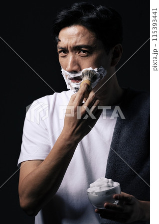 a middle aged man foaming his chin with a shaving brush a middle aged man foaming his chin with a shaving brush 115393441