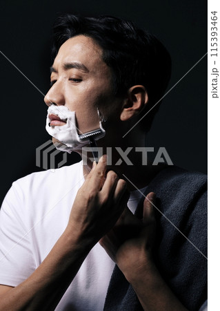 a middle aged man shaving with foam 115393464