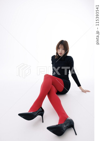 Korean Woman Sitting on the Floor in a Black Dress and Red Leggings 115393541