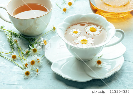 Chamomile flower tea. A tea cup and a tea pot with fresh medicinal flowers Chamomile flower tea. A tea cup and a tea pot with fresh medicinal flowers 115394523