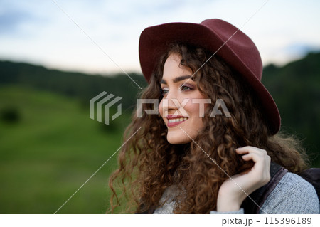 Young tourist woman traveller with backpack walking in nature. Active hiker on trail in mountains enjoying sunset. 115396189