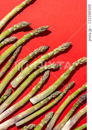 Green asparagus on red background. Vegetable food top view. 115398309