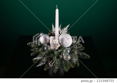 Candle Resting on Christmas Arrangement Candle Resting on Christmas Arrangement 115398755