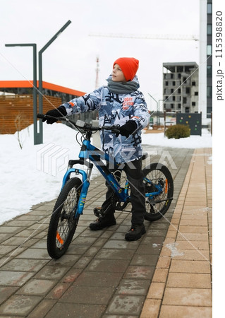 A male child rides a sports bike in the cold season A male child rides a sports bike in the cold season 115398820