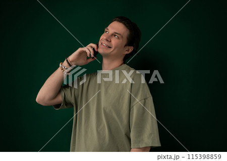 Man Talking on Cell Phone in Front of Green Wall Man Talking on Cell Phone in Front of Green Wall 115398859
