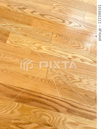 Detailed close-up image showcasing a visible scratch on a hardwood floor. The image highlights the texture and grain of the wood along with the imperfection, illustrating the common wear and tear in 115399101