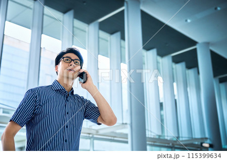 スマホで電話する半袖シャツを着た若いビジネスマン 115399634
