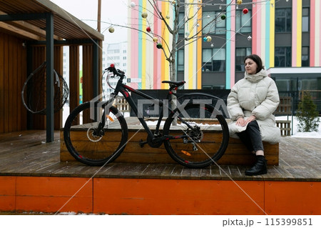 Woman Sitting on Bench Next to Bike Woman Sitting on Bench Next to Bike 115399851