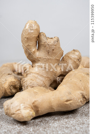 Fresh ginger roots on gray stone background close-up. Fresh ginger roots on gray stone background close-up. 115399950