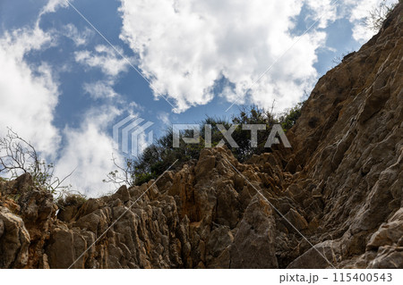 Rocky cliff with blue sky and clouds 115400543
