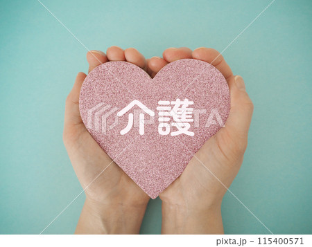 手に持ったハートに介護の文字 115400571