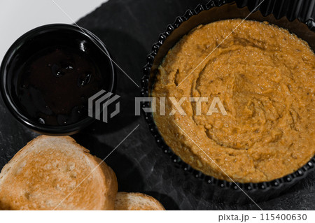 Pate with sauce and croutons on a black board on a white background 115400630