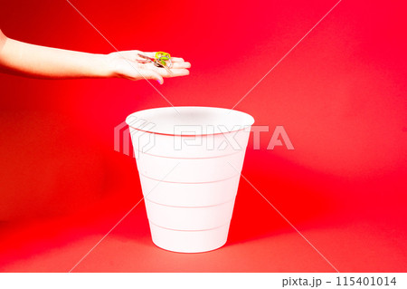 A hand is about to throw a bunch of keys into the trash can. Real estate price change concept 115401014